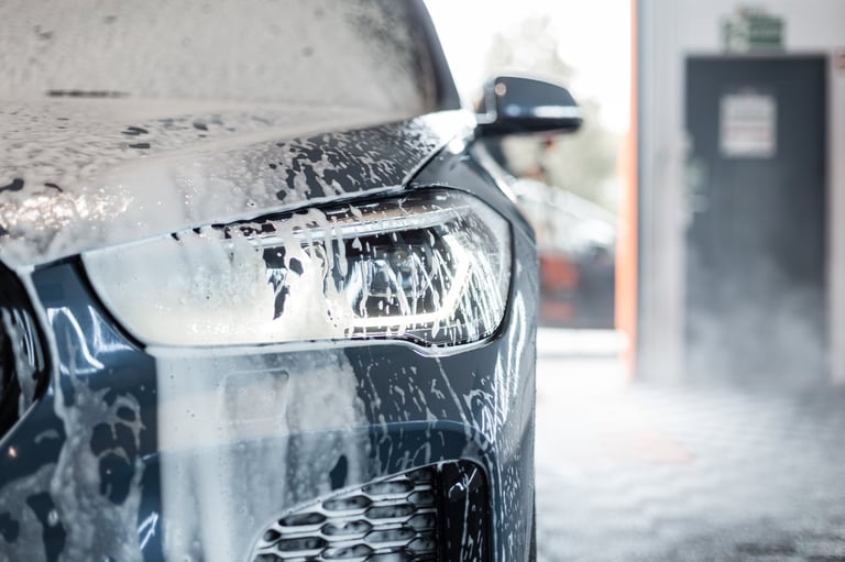 Car with optics in foam at the car wash in the garage