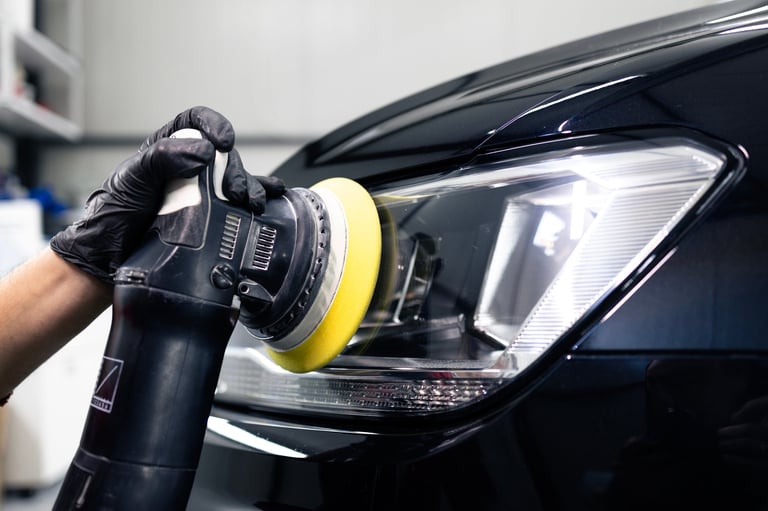 Expert polishing car headlights in auto repair shop