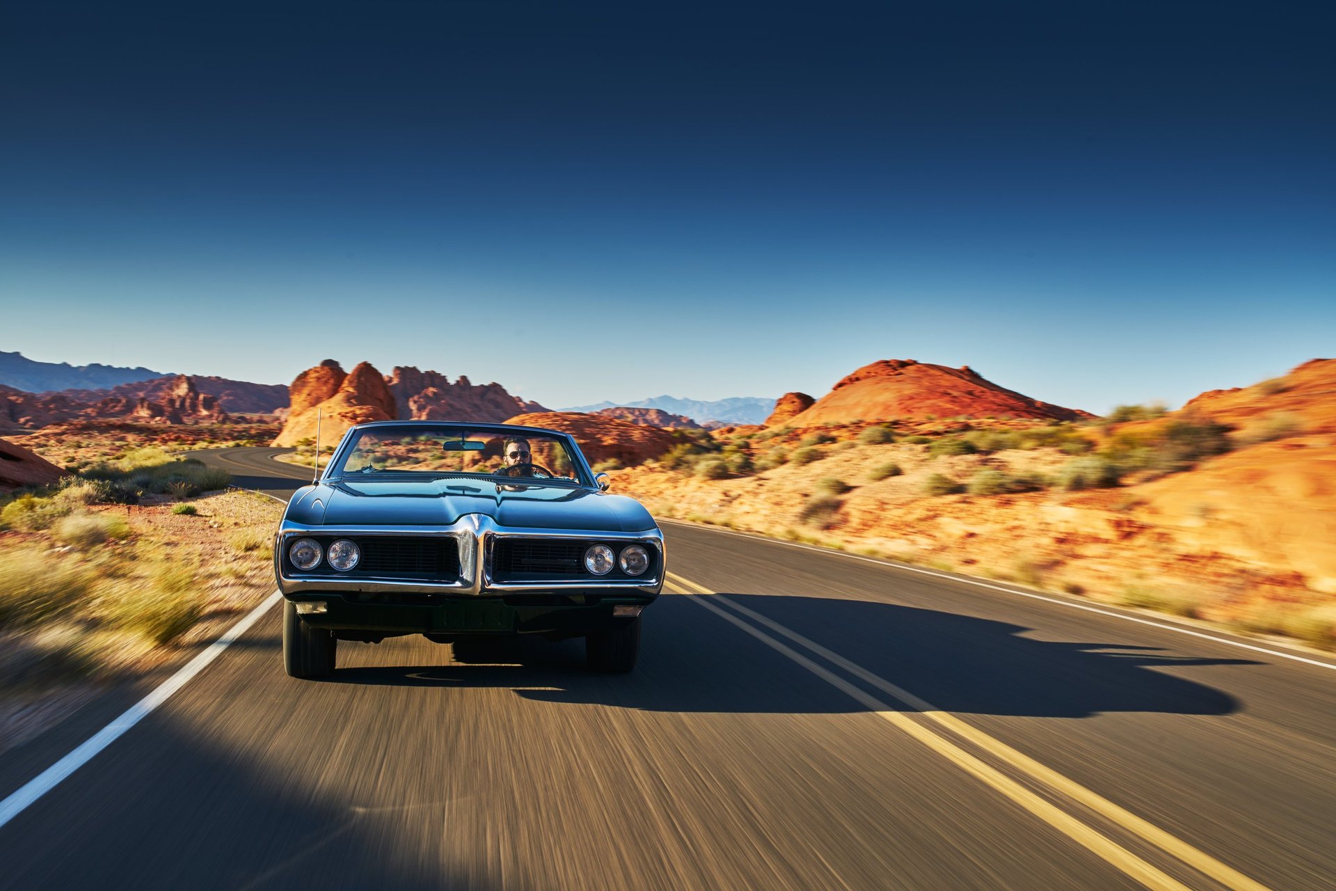 Vintage car driving through desert